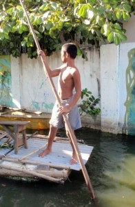 Manila 059 (480x640) (409x626) A boy rows a skiff down a flooded street in Rizal Province, Philippines