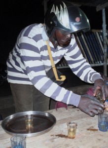 A motorcycle taxi driver pours moonshine in Lome, Togo